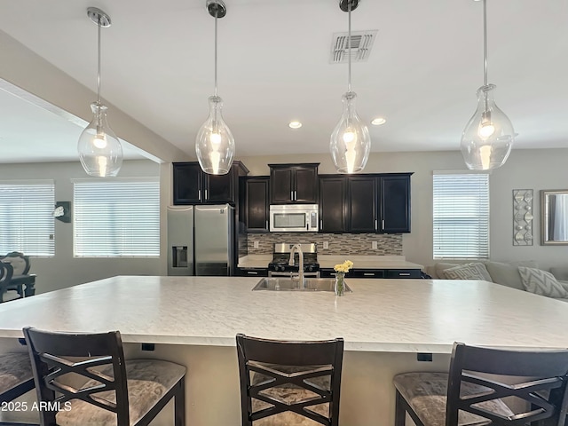 kitchen featuring visible vents, backsplash, open floor plan, light countertops, and appliances with stainless steel finishes