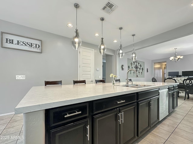 kitchen with a sink, visible vents, dark cabinets, and light tile patterned floors