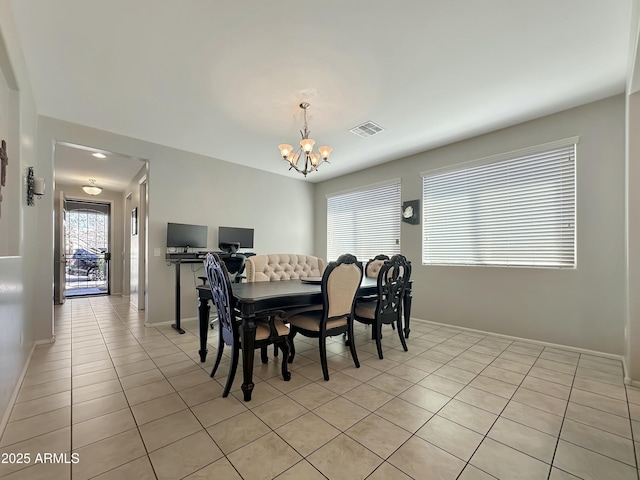 dining area featuring a notable chandelier, visible vents, baseboards, and light tile patterned floors