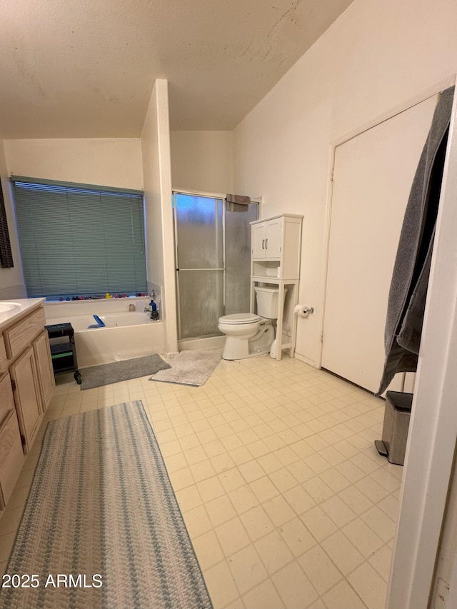 bathroom with a bathing tub, vanity, tile patterned floors, and toilet