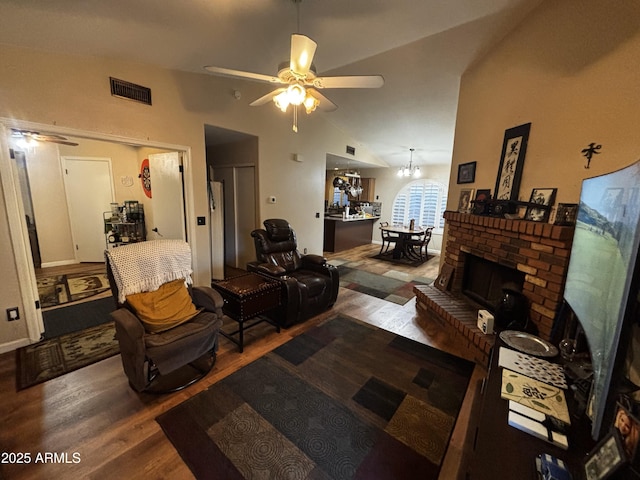 living room featuring hardwood / wood-style flooring, lofted ceiling, ceiling fan, and a brick fireplace