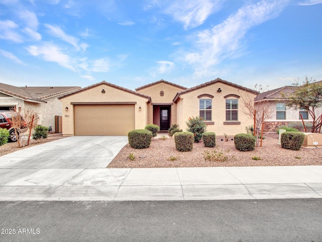 mediterranean / spanish house featuring stucco siding, a garage, driveway, and a tiled roof