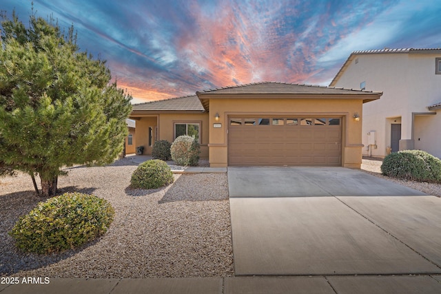 view of front facade featuring stucco siding, a garage, driveway, and a tiled roof