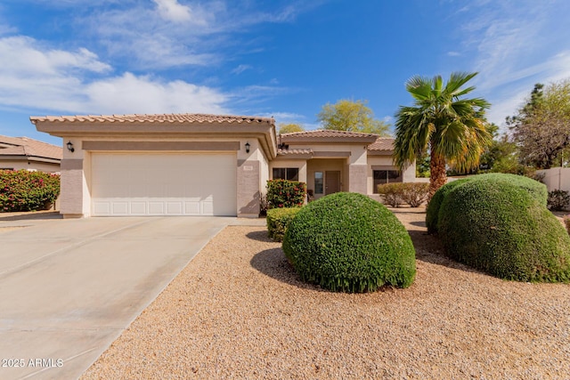 view of front of property featuring stucco siding, driveway, an attached garage, and a tile roof