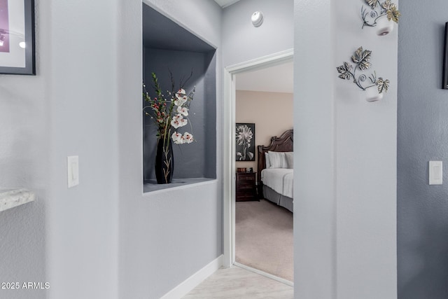 corridor with baseboards and carpet flooring