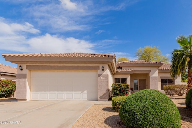 mediterranean / spanish home with stucco siding, a garage, driveway, and a tiled roof