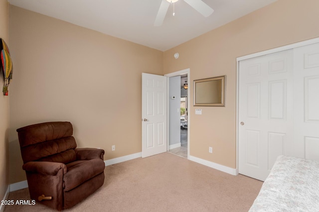 living area featuring ceiling fan, baseboards, and light carpet