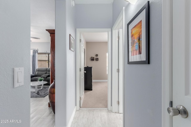 hall with light wood finished floors and baseboards