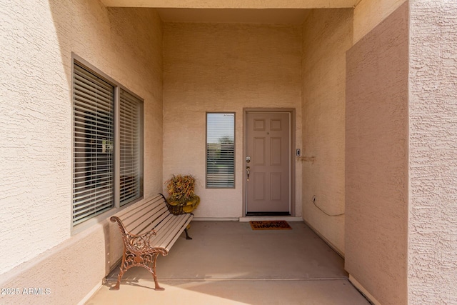 doorway to property featuring stucco siding