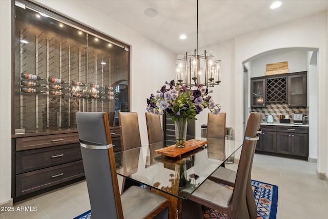15711 S 11th Ave, Phoenix, AZ 85045 - dining space featuring light tile patterned flooring, a chandelier, recessed lighting, arched walkways, and a bar