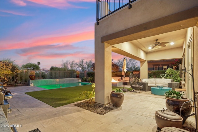 15711 S 11th Ave, Phoenix, AZ 85045 - pool at dusk with outdoor lounge area, a patio area, a ceiling fan, and a fenced backyard