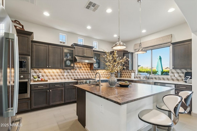 15711 S 11th Ave, Phoenix, AZ 85045 - kitchen featuring appliances with stainless steel finishes, under cabinet range hood, backsplash, plenty of natural light, and recessed lighting