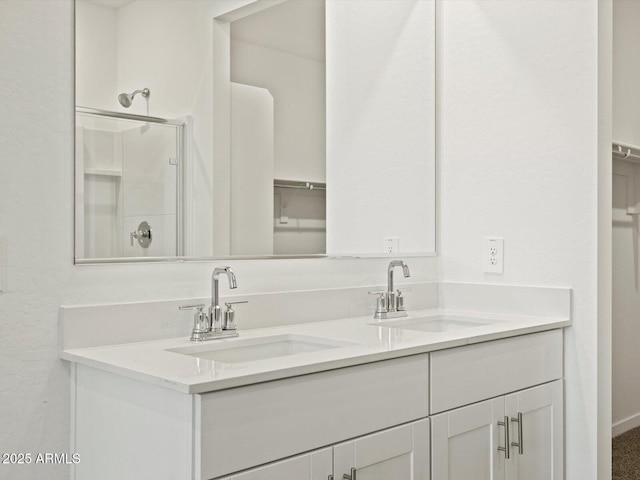 full bathroom with a sink, a shower stall, and double vanity