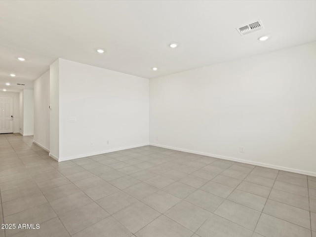 spare room featuring baseboards, visible vents, and recessed lighting