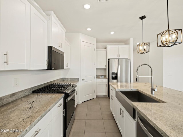 kitchen featuring white cabinets, stainless steel appliances, a sink, and light tile patterned flooring