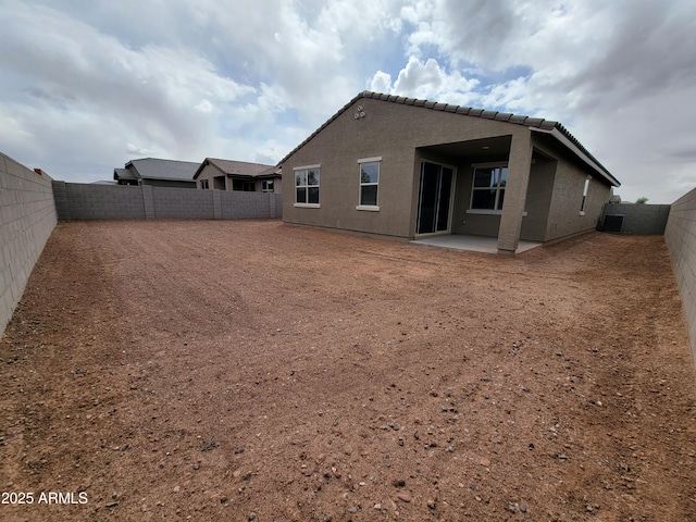 rear view of house with a patio area, a fenced backyard, and stucco siding