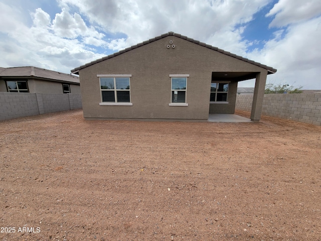 rear view of property featuring a patio area, a fenced backyard, and stucco siding