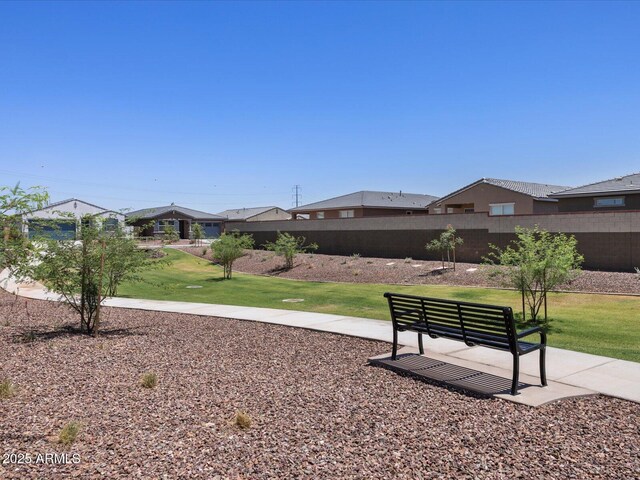 view of home's community with fence and a yard