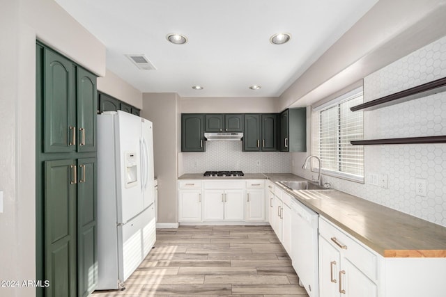 kitchen featuring light wood-type flooring, tasteful backsplash, white appliances, sink, and white cabinets