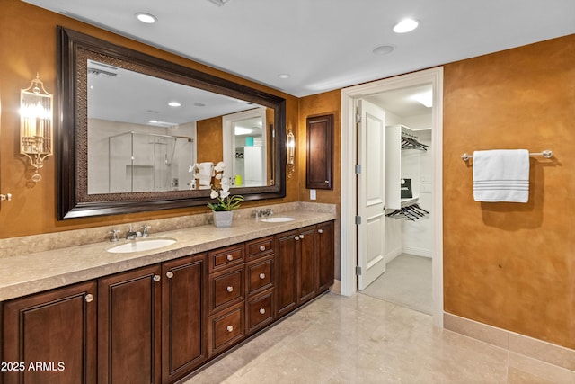 bathroom featuring a shower with door and vanity