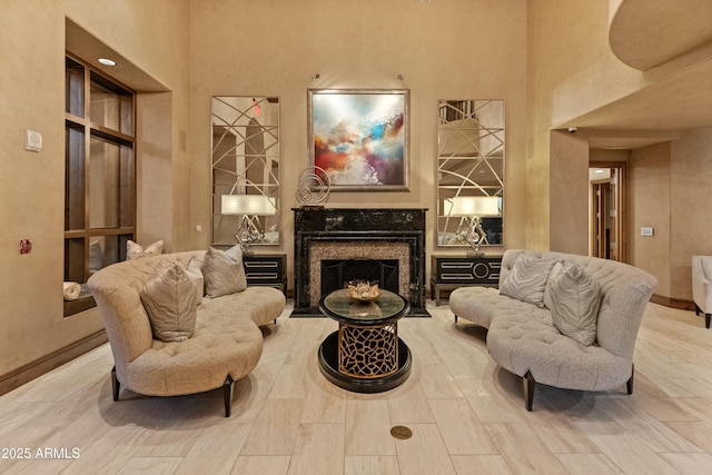 living area with a fireplace and a high ceiling