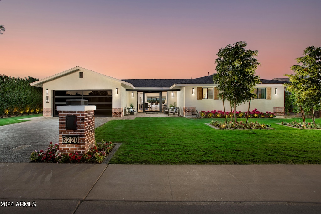 view of front of property with a garage and a yard