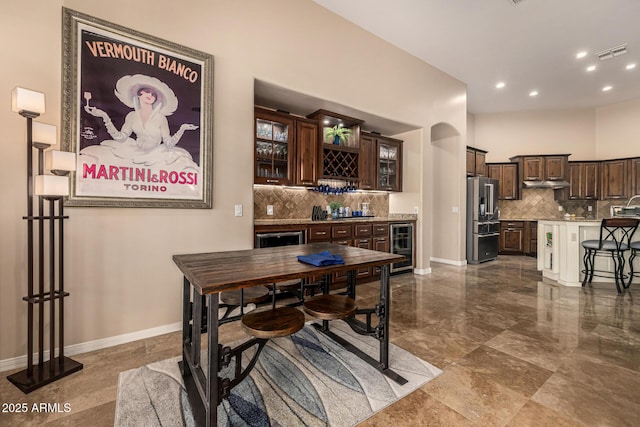 dining area with wine cooler, recessed lighting, visible vents, wet bar, and baseboards