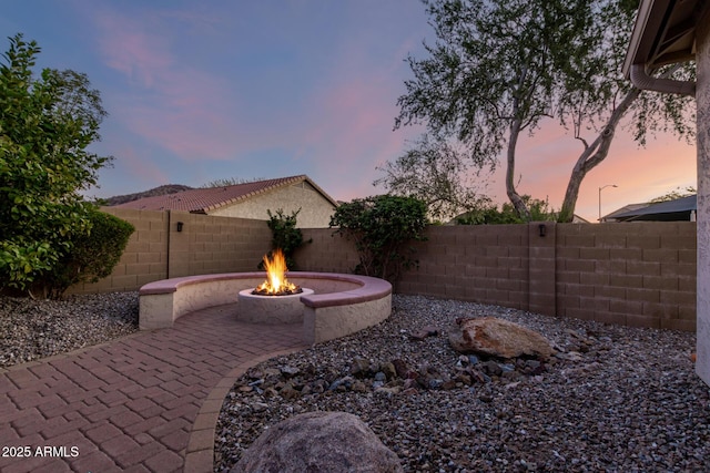 5607 W Alyssa Ln, Phoenix, AZ 85083 - yard at dusk with an outdoor fire pit, a patio, and a fenced backyard