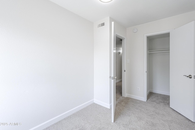 unfurnished bedroom featuring a closet, carpet floors, visible vents, and baseboards