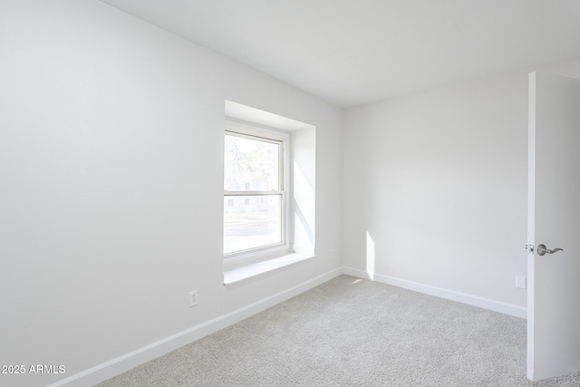 empty room featuring carpet and baseboards