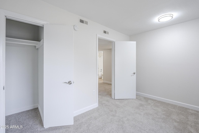 unfurnished bedroom with a closet, visible vents, carpet flooring, and baseboards