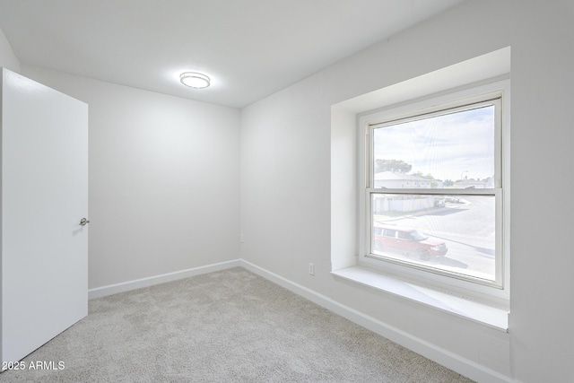 carpeted empty room with baseboards