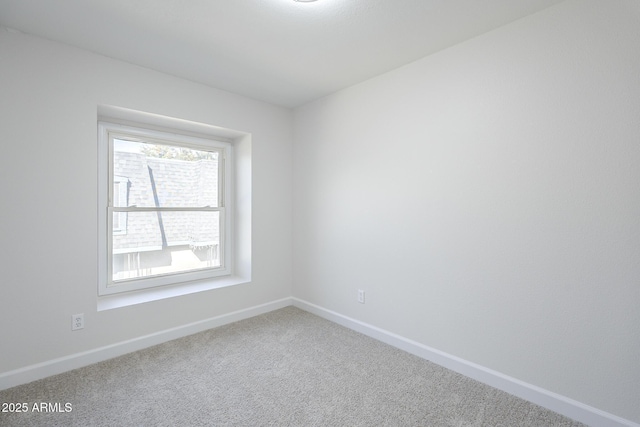 carpeted spare room featuring baseboards