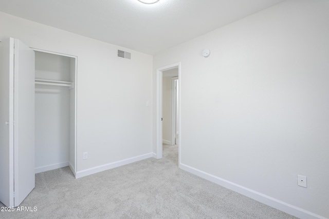 unfurnished bedroom with baseboards, carpet flooring, visible vents, and a closet