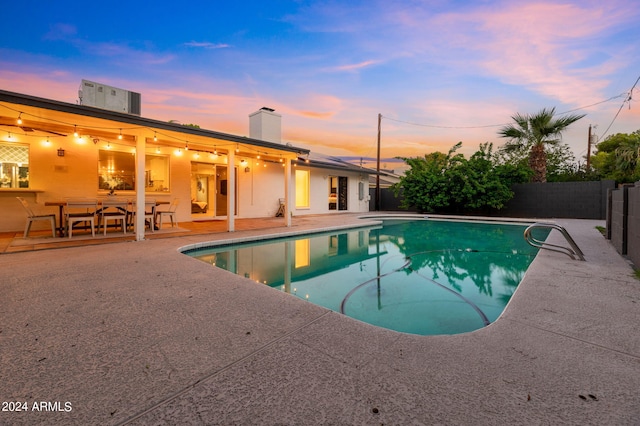 pool at dusk with a patio