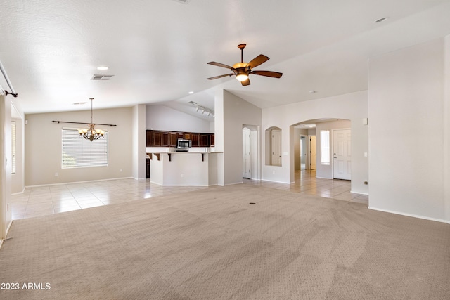 unfurnished living room with ceiling fan with notable chandelier, light colored carpet, and lofted ceiling