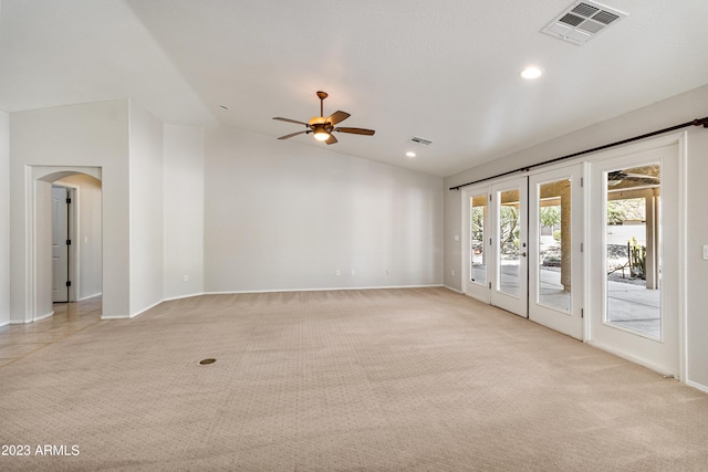 empty room with ceiling fan, light colored carpet, and french doors