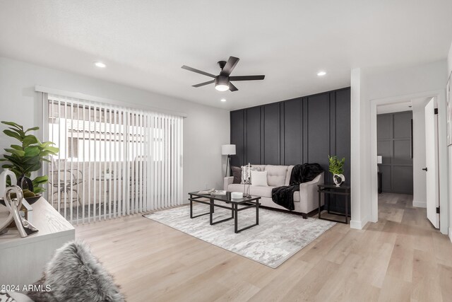 living room featuring light hardwood / wood-style flooring and ceiling fan