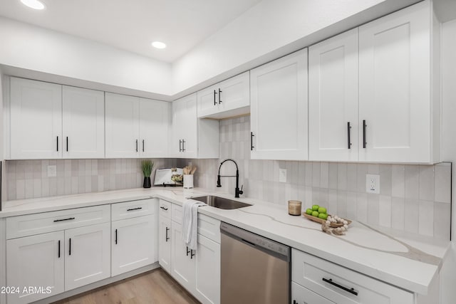 kitchen featuring dishwasher, white cabinets, light wood-type flooring, and sink