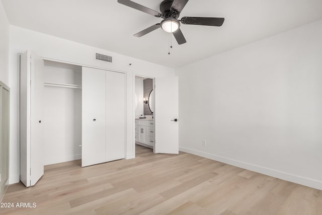 unfurnished bedroom featuring light wood-type flooring, a closet, ceiling fan, and connected bathroom