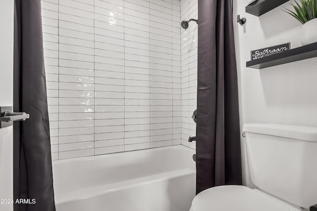 bathroom featuring shower / tub combo and toilet