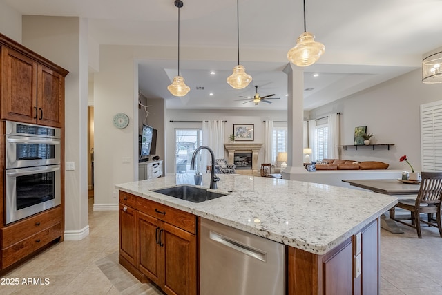 kitchen featuring pendant lighting, a kitchen island with sink, sink, ceiling fan, and stainless steel appliances