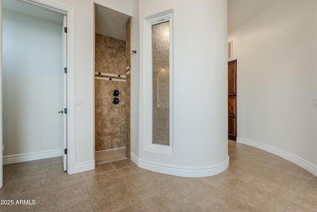 bathroom with tile patterned flooring and tiled shower