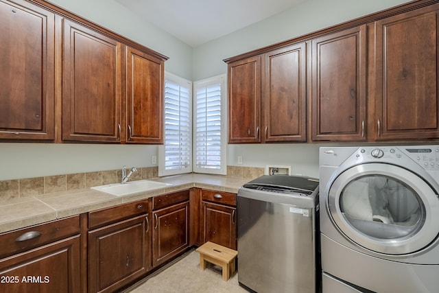 laundry room with cabinets, separate washer and dryer, and sink