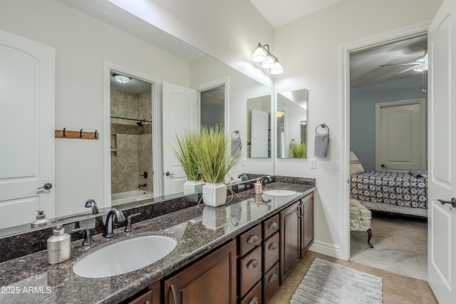 bathroom with tile patterned flooring, tiled shower / bath, vanity, and ceiling fan