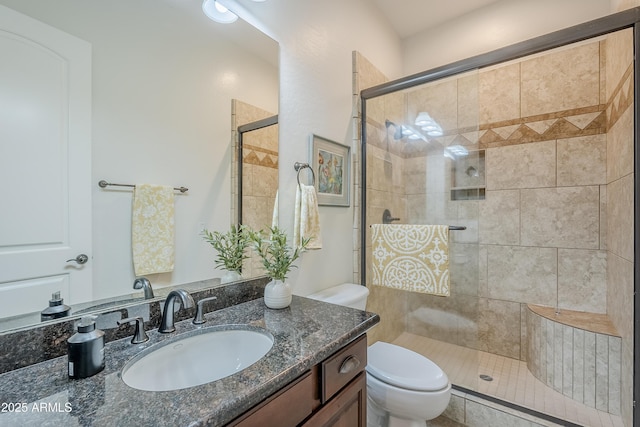 bathroom featuring vanity, toilet, and an enclosed shower