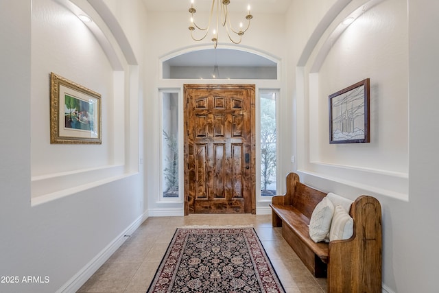 tiled foyer featuring a notable chandelier