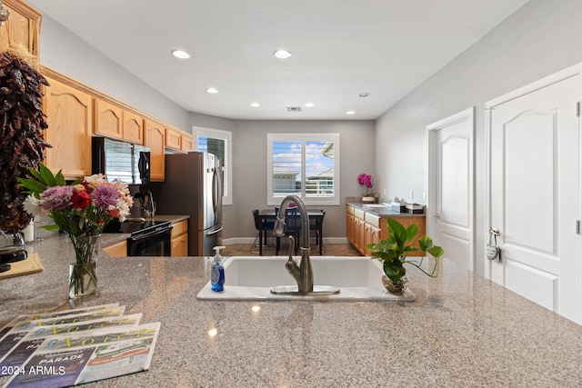 kitchen featuring sink, light brown cabinets, and black appliances