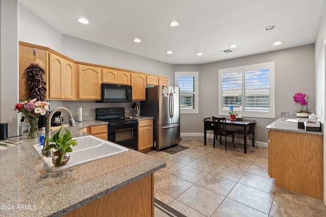 kitchen featuring black appliances, light stone countertops, sink, kitchen peninsula, and light tile patterned flooring