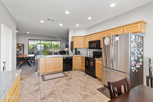 kitchen featuring kitchen peninsula, light brown cabinets, sink, light stone counters, and black appliances